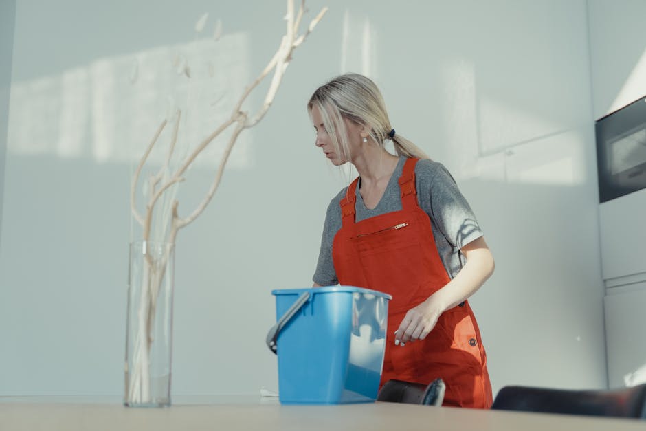 Smiling professional cleaner standing in a well-maintained home